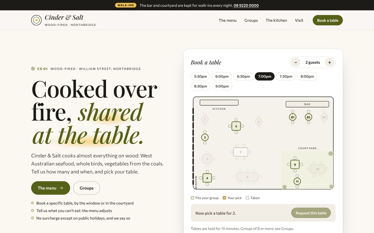 Mise template home page: a serif headline 'Cooked over fire, shared at the table.' with the last words in olive italics on a saffron smear, beside a floor plan of a restaurant with numbered tables and chairs, a kitchen counter, a bar and a green courtyard, with times above and a request button below
